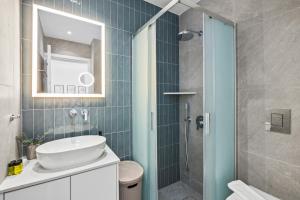 a bathroom with a sink and a shower with a mirror at Artemis 103 - Seaside Stories in Livadhia