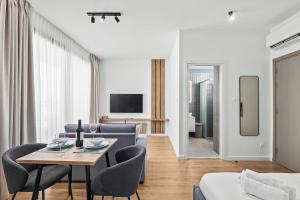 a living room with a table and chairs and a couch at Artemis 103 - Seaside Stories in Livadhia +20 photos