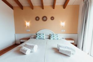 a bedroom with a large white bed with two pillows at Villas Amarillas in Cala Blanca +39 photos