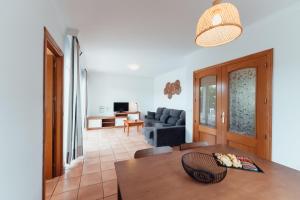 a living room with a table and a couch at Villas Amarillas in Cala Blanca