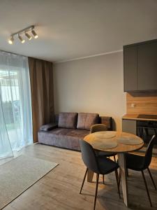 a living room with a table and a couch at Apartament Lazurowy Olsztyn in Olsztyn