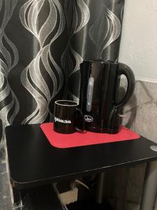 two black coffee cups sitting on a red shelf at Private stay @ London-Stratford. in London