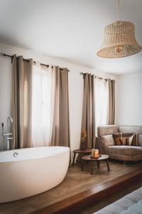 a bathroom with a bath tub and a couch at Cangalho Village House Premium in Azueira