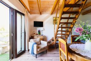 a living room with a spiral staircase and a couch at Apartamenty na Pastwisku in Szymbark