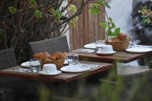a table with plates and glasses and bread on it at Hôtel Restaurant Petra Cinta in Barcaggio