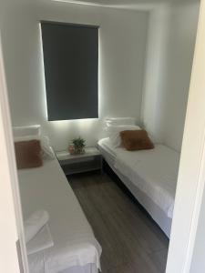 two beds in a room with white walls and a window at Mobile home La Bella in Drage