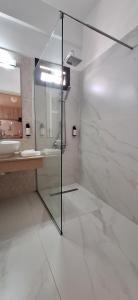 a bathroom with a glass shower and a sink at Anna Hotel Apartments in Paphos City