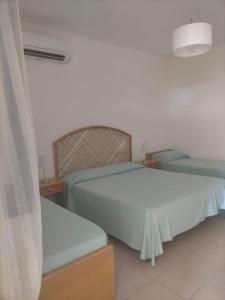 a bedroom with a white bed and a chair at Villaggio Athragon in Capo Vaticano +72 photos