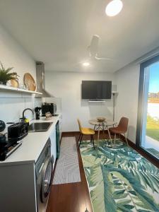 a kitchen with a sink and a table with chairs at Puesta de Sol Doñana Adults Only in Sanlúcar de Barrameda