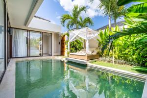 an infinity pool in a villa with a garden at Frelin Villas - 1 BR, 2 BR Luxury Villa Complex in Kerobokan
