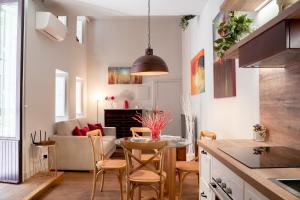 Una cocina y una sala de estar con mesa y sillas. en Four Elements Apartments, en Catania
