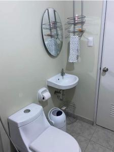 a bathroom with a toilet and a sink and a mirror at Amaia Steps Altaraza Staycation in Sapang Alat