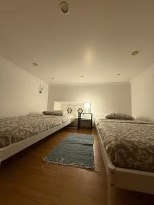 une chambre avec deux lits et un tapis dans l'établissement Faro Coast Guest House, à Faro