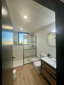 a bathroom with a toilet and a sink and a mirror at Puesta de Sol Doñana Adults Only in Sanlúcar de Barrameda