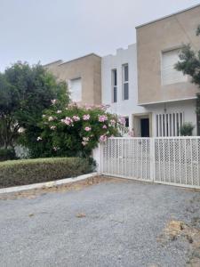 a white picket fence in front of a house at Beau Duplex bay3 in Sidi Bouzid