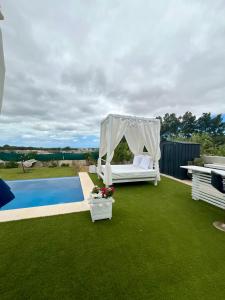 a backyard with a canopy bed and a pool at Puesta de Sol Doñana Adults Only in Sanlúcar de Barrameda