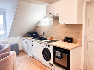 a kitchen with a washer and a sink and a stove at La Loge et La Pause Compiègnoise in Compiègne