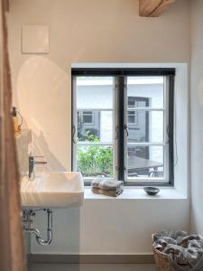 a bathroom with a sink and a window at Ferienwohnung 2, Schlaf-Gut-Johannis, Flensburg in Flensburg