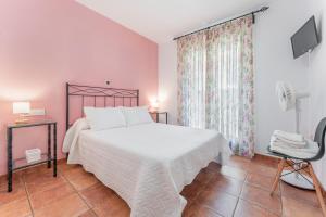 a bedroom with a white bed and a chair at Hotel El Horno in La Puebla de Valverde