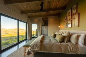 a bedroom with a large bed with a large window at Hideaways Cape Point Hideaway in Cape Town +34 photos