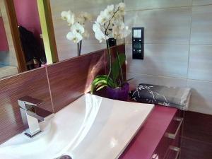 a bathroom with a sink with flowers on a counter at Apartment Mestwina in Gdynia