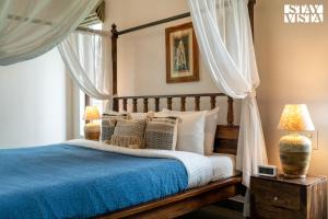 Un dormitorio con una cama con sábanas y almohadas azules. en Stayvista at Serenova with big pvt pool and lawn - Your Luxury escape awaits !, en Madikeri