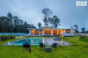 a man standing in front of a house with a pool at Serenova 4BR with big pvt pool and lawn - Your escape awaits ! in Madikeri