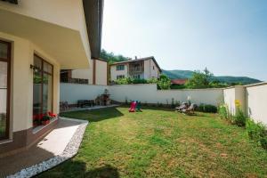 a backyard of a house with a grass yard at Pavlina Guest House in Tsŭrvishte