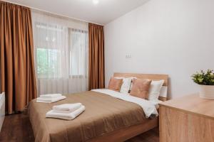 a bedroom with a large bed with towels on it at Pavlina Guest House in Tsŭrvishte
