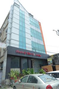 Un hotel con un coche aparcado delante. en Hotel Shri Bhaskar, en Bareilly