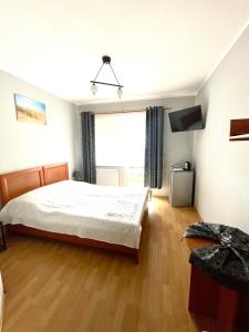 a bedroom with a bed and a large window at Pensjonat Bryza in Karwia