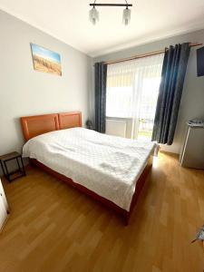 a bedroom with a bed and a large window at Pensjonat Bryza in Karwia