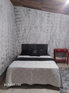 a bedroom with a bed with a gray wall at Casa de Campo in Santo André