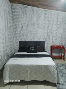 a bedroom with a bed and a red table at Casa de Campo in Santo André