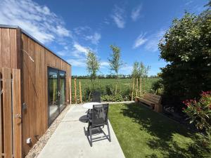 a patio with a table and chairs in a yard at Vakantiehuis Blik op Zoutelande in Biggekerke