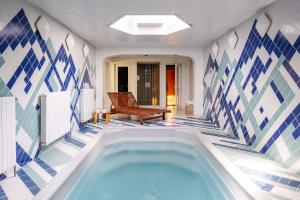 ペツ・ポト・スニェシュコウにあるHotel Hořecの青と白のタイル張りの客室内のバスタブ