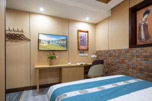 a hotel room with a bed and a desk at East Sacred Hotel-Very close to the Drum Tower,The Lama Temple,Houhai Bar Street,Nanluoguxiang,Tiananmen Square and the Forbidden City, and the subway st ation is also very close in Beijing
