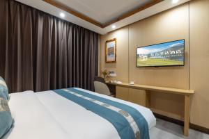 a hotel room with a bed and a desk at East Sacred Hotel-Very close to the Drum Tower,The Lama Temple,Houhai Bar Street,Nanluoguxiang,Tiananmen Square and the Forbidden City, and the subway st ation is also very close in Beijing
