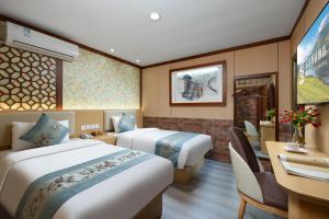 a hotel room with two beds and a desk at East Sacred Hotel-Very close to the Drum Tower,The Lama Temple,Houhai Bar Street,Nanluoguxiang,Tiananmen Square and the Forbidden City, and the subway st ation is also very close in Beijing
