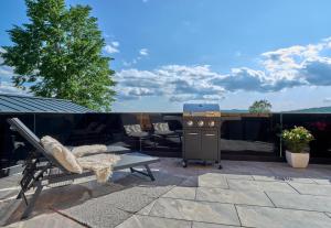 a patio with a grill and a bench and a table at Luxus Chalet Zur Resi in Mauth +100 photos