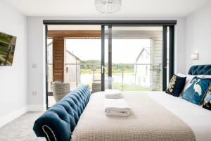 a bedroom with a large bed with a blue couch at Howard Lodge BV27 Silverlake Dorset in Warmwell