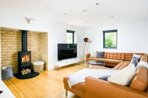 a living room with a couch and a fireplace at Howard Lodge BV27 Silverlake Dorset in Warmwell