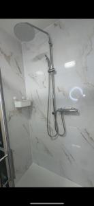 a shower in a bathroom with white marble walls at L'Échappée Occitane - Harmonie et Douceur de Vivre - Clim in Montauban +13 photos