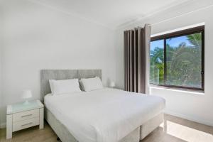 a white bedroom with a large bed and a window at Ultimate Bondi Escape #2 Stunning Views ! in Sydney