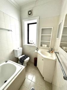 a bathroom with a tub and a toilet and a sink at Ultimate Bondi Escape #2 Stunning Views ! in Sydney