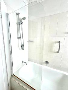 a white bathroom with a tub and a shower at Ultimate Bondi Escape #2 Stunning Views ! in Sydney +29 photos