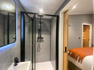 Un baño con ducha y lavabo y una cama. en P59 - Riverstone with hot tub, en Bethesda