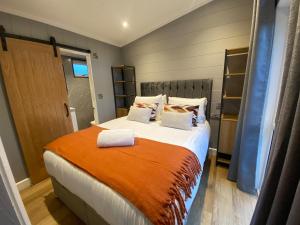 Un dormitorio con una cama grande con una manta naranja. en P59 - Riverstone with hot tub, en Bethesda