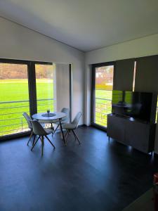 a living room with a table and chairs and a television at Stadt und See Nahes Appartment in Klagenfurt +10 photos