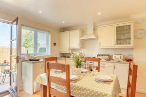 a kitchen with a table and chairs and a kitchen with white cabinets at 2 Bed in St. Issey oc-a32428 in Saint Issey +20 photos